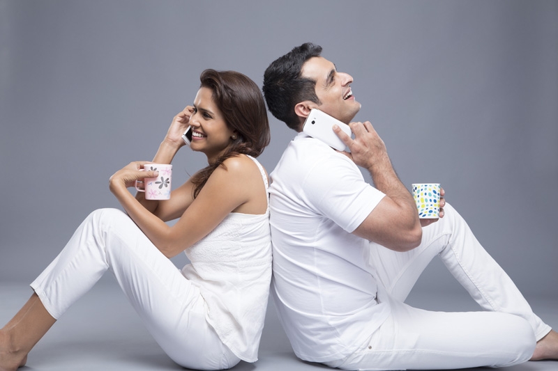 couple talking on the phone while drinking coffee