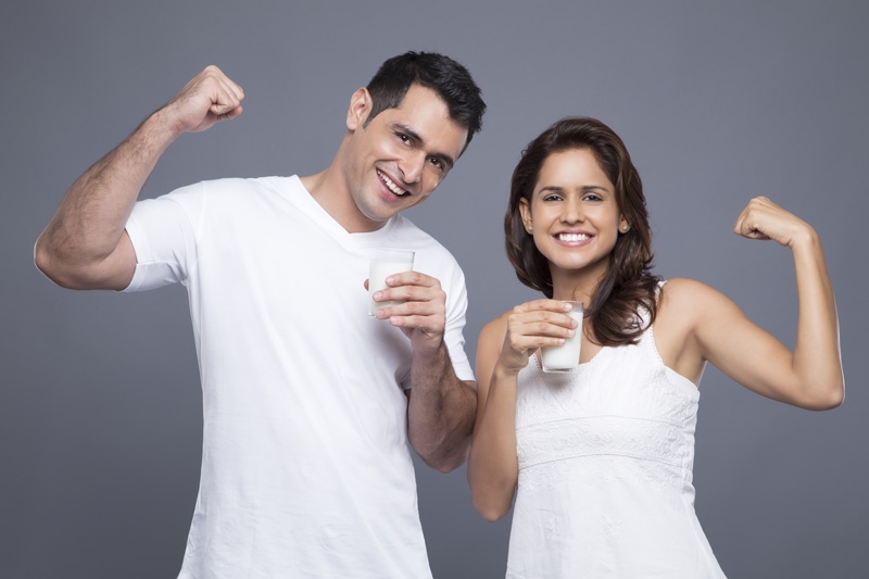 couple drinking milk and showing biceps