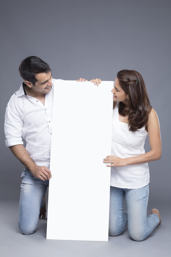 young couple holding a blank poster