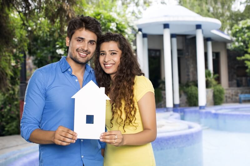 couple showing home cutout outside villa