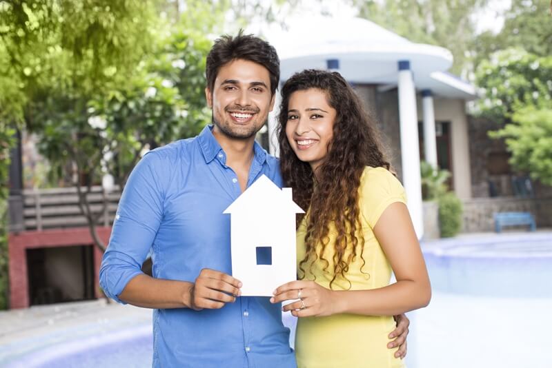 couple showing home cutout outside villa