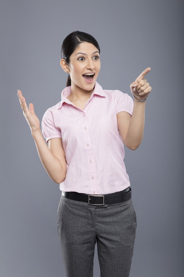 cheerful beautiful business woman pointing and looking at copyspace