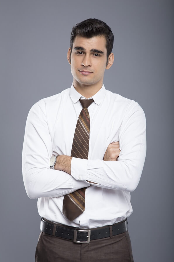 professionally dressed man standing with folded hands 
