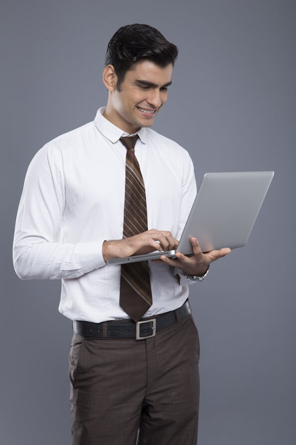 professionally dressed man working on a laptop 