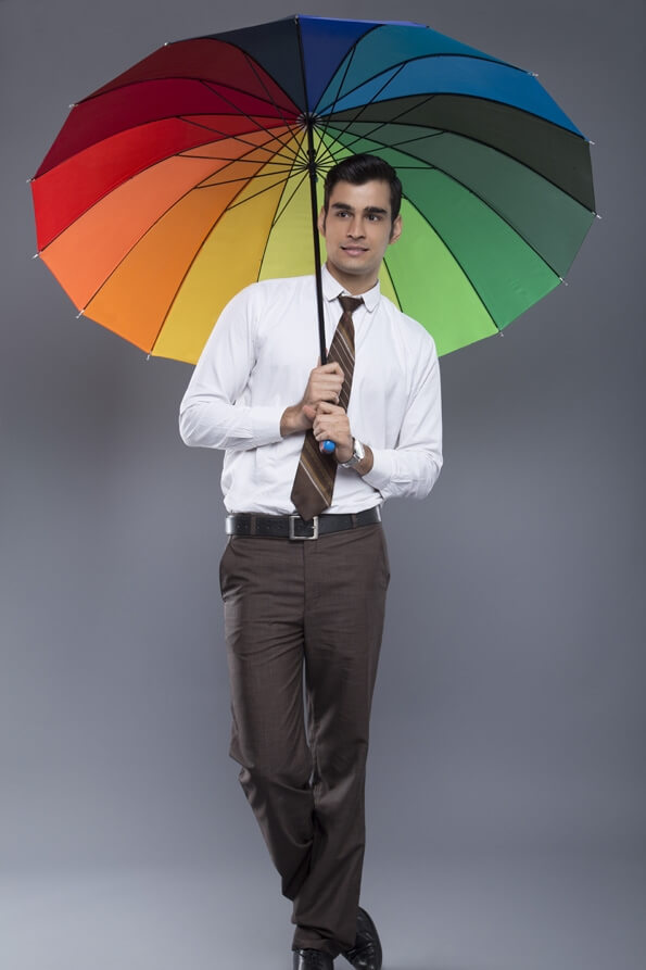 man in formal clothes posing with an umbrella 
