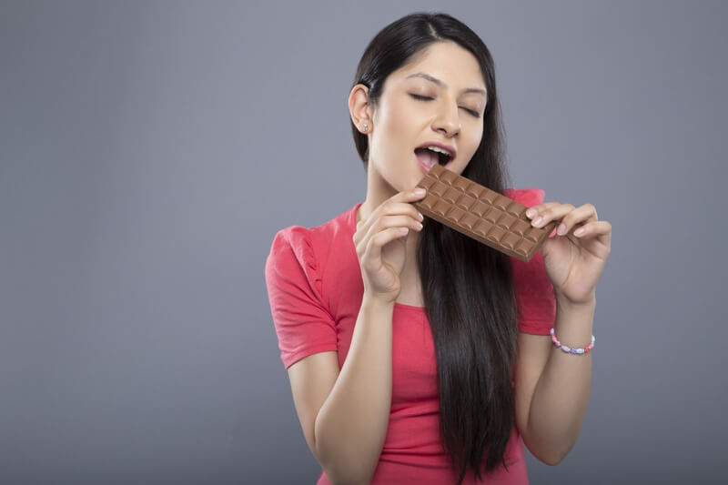 woman posing with a chocolate bar