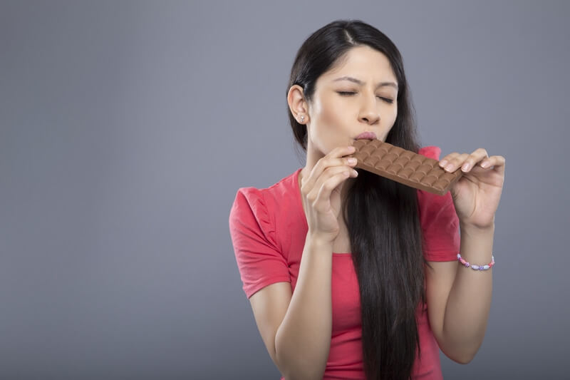 woman posing with a chocolate bar
