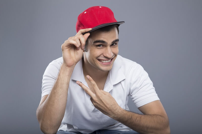 man in casuals posing with cap 