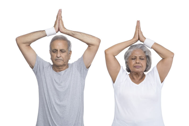 old couple doing yoga in gym wear 