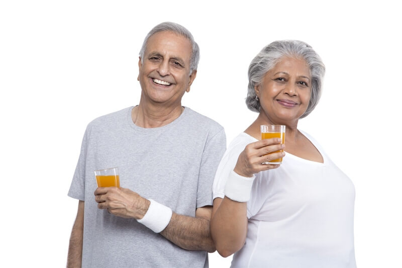 old couple with orange juice glasses 