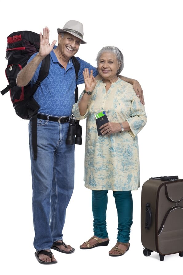 old couple with luggage waving hands