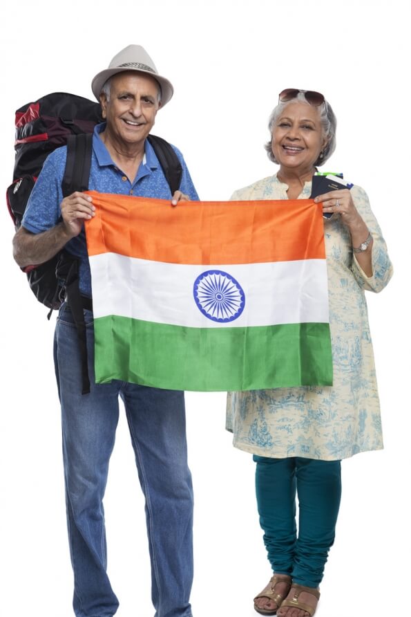 old couple with indian flag and carrying travelling bags 