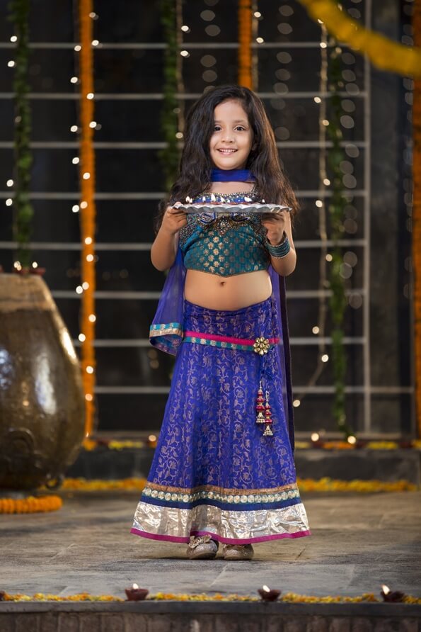 sweet girl holding a pooja thali on diwali