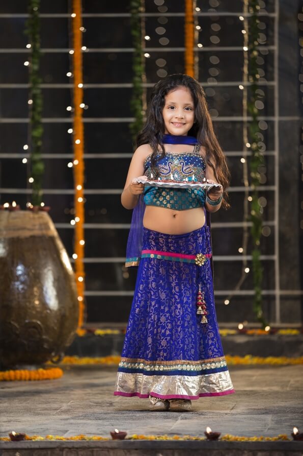 sweet girl holding a pooja thali on diwali