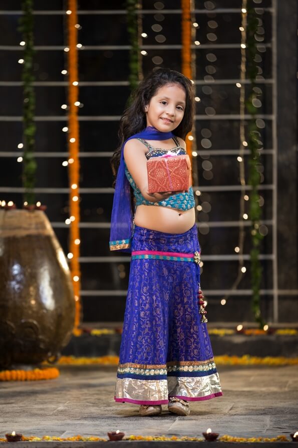 cheerful small girl offering a present on diwali
