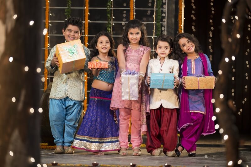 group of kids carrying gifts and presents on diwali