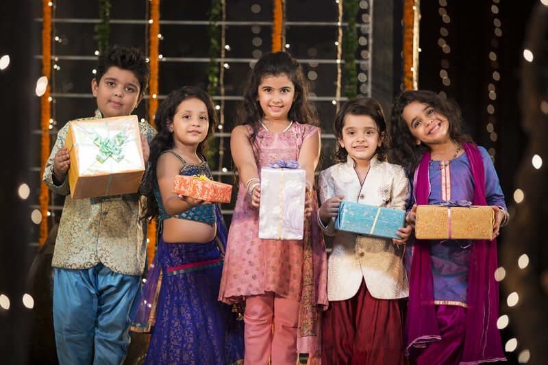 group of kids carrying gifts and presents on diwali
