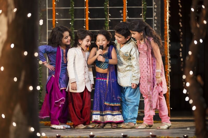 group of kids singing a song on a microphone on diwali