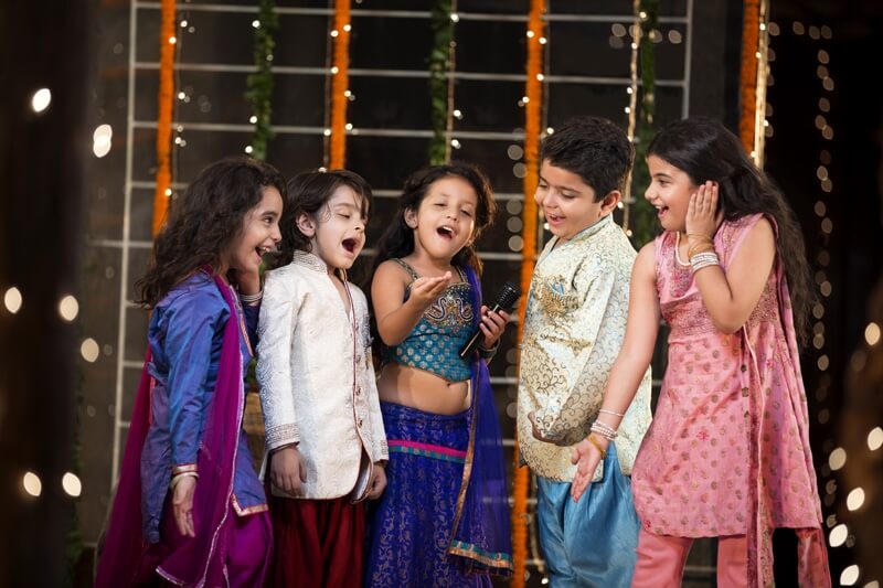 group of kids singing a song on a microphone on diwali