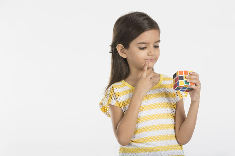 baby girl solving solving puzzle cube