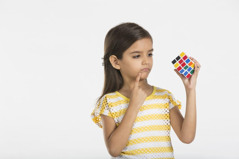 baby girl solving solving puzzle cube