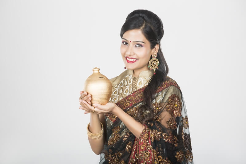 woman in saree with piggy bank 