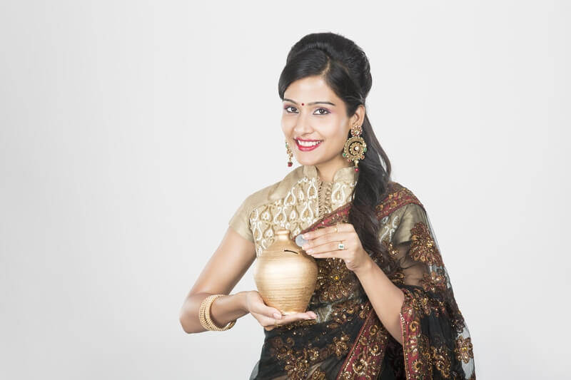 woman in saree with piggy bank 