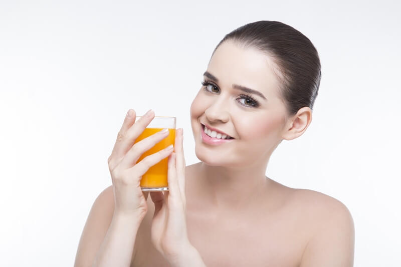 beautiful girl posing with a glass of orange juice