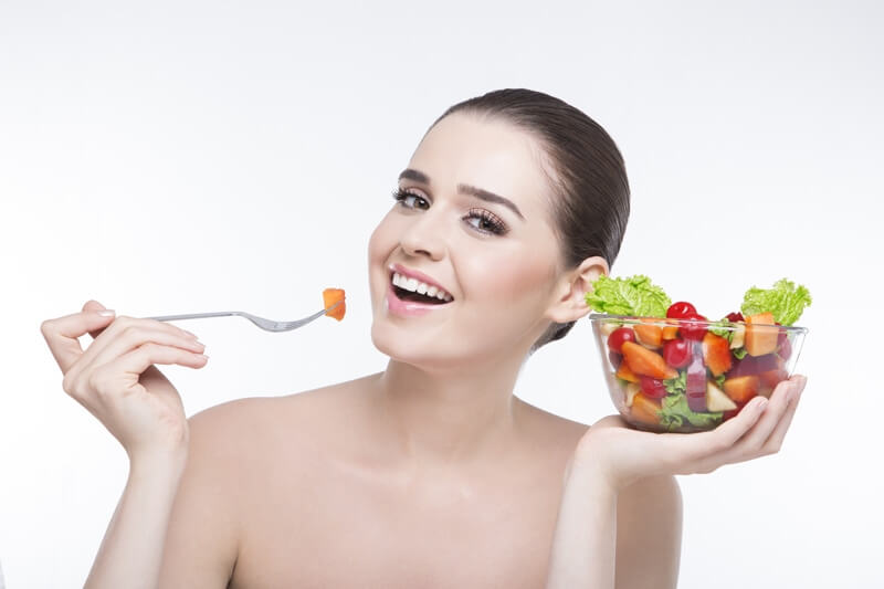 girl posing with a bowl full of salad 