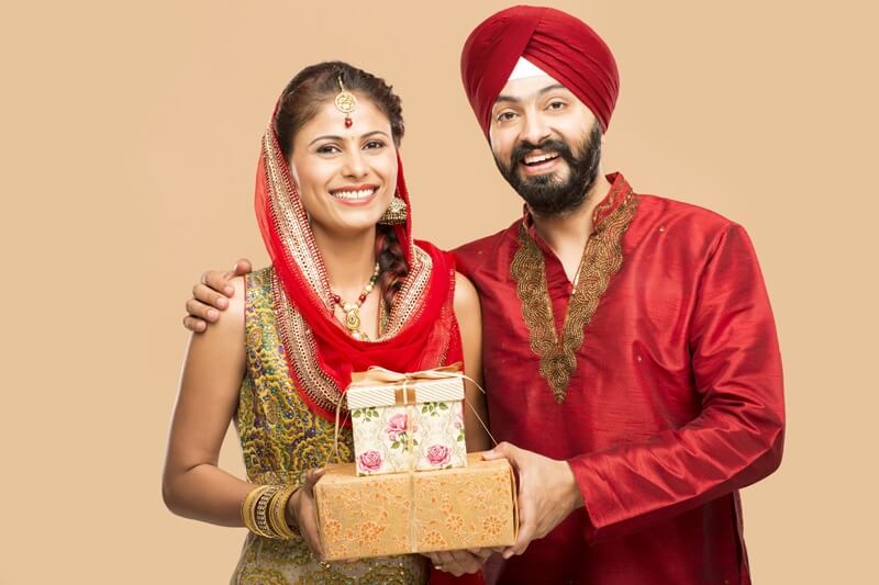 sikh couple posing with gifts 