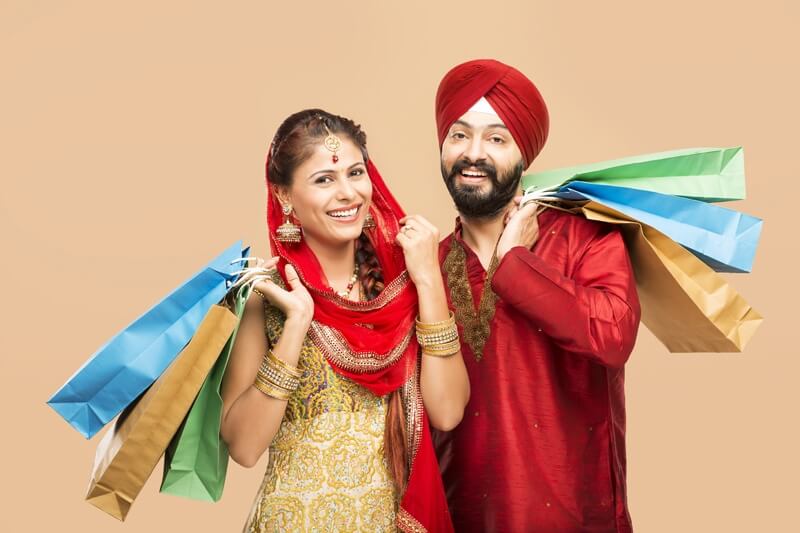 sikh couple posing with gifts and sweets