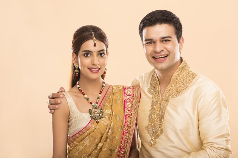 hindu couple in traditional clothes smiling and posing 