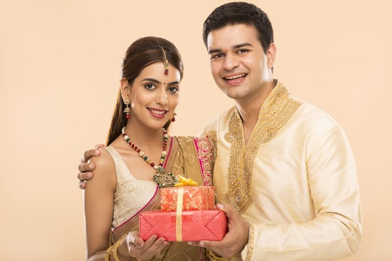 hindu couple in traditional clothes with gifts 
