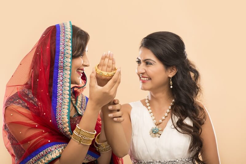woman giving bangle to another woman