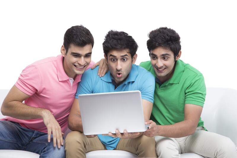 three friends looking at the laptop in surprise