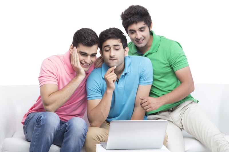 friends having fun time while browsing on laptop