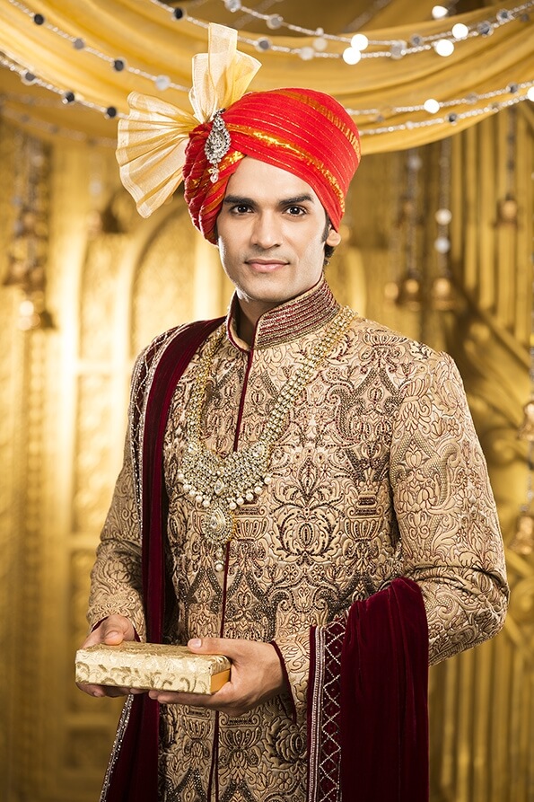 indian groom posing with a gift box