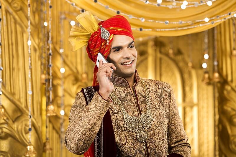 indian groom talking on phone 