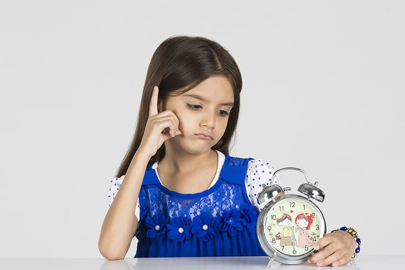 baby girl posing with a table clock