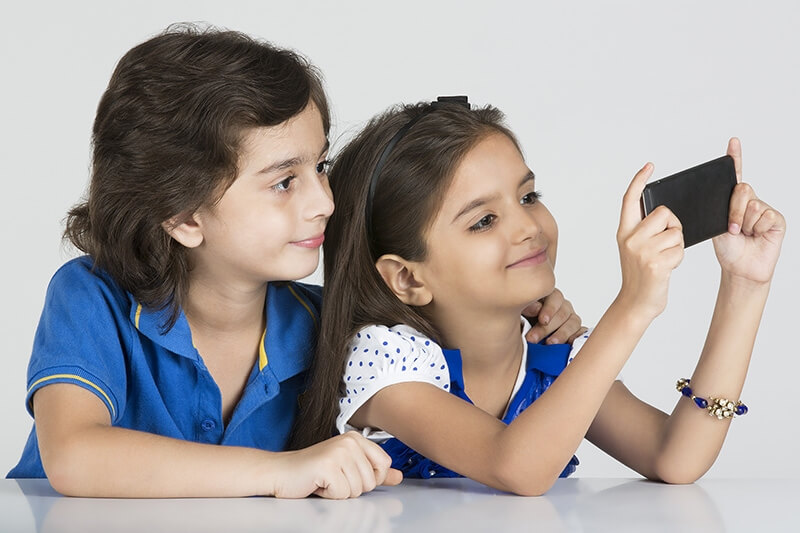two kids playing with mobile phone