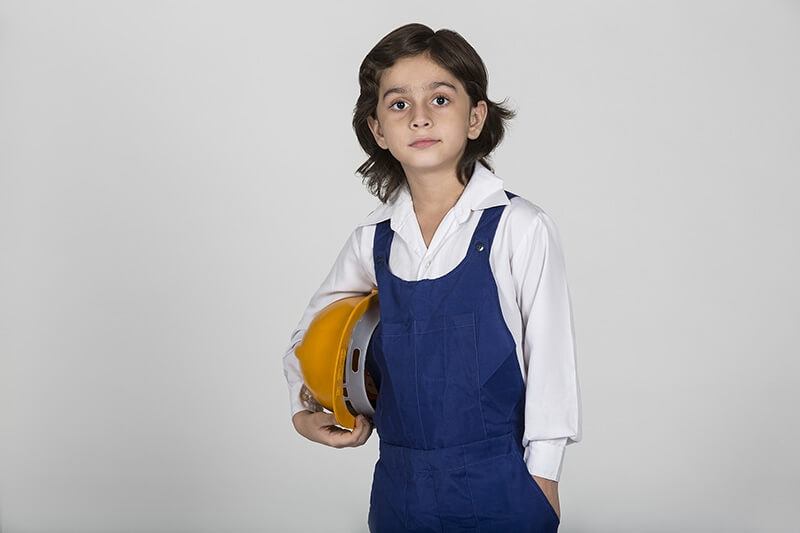 young child posing with hardhat as constructor