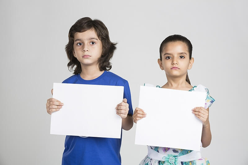 two kids showing blank placard