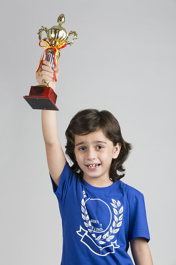 child posing with trophy