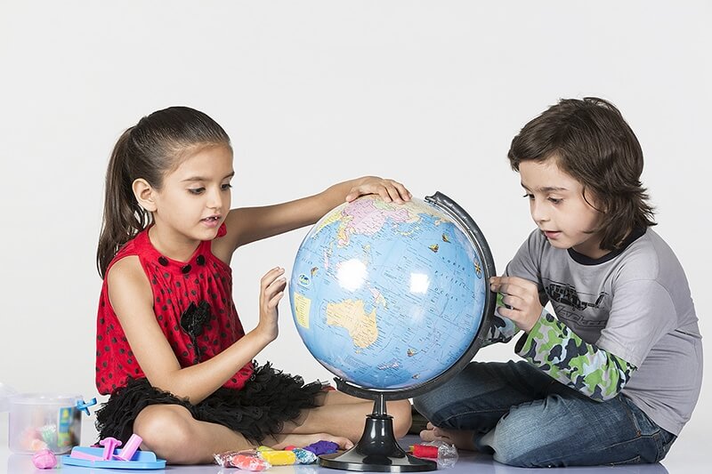 two kids playing with globe