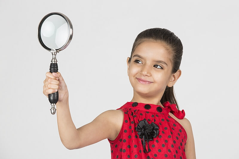 child playing with magnifying glass