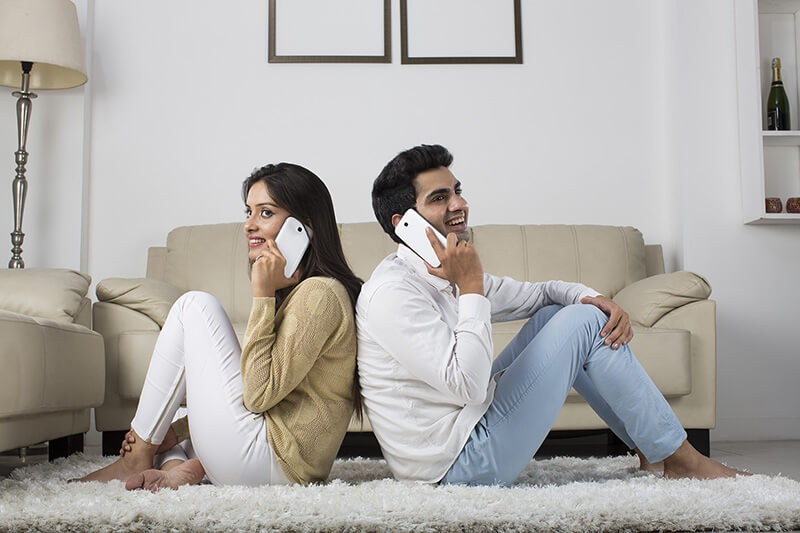 couple at home talking on mobile phone