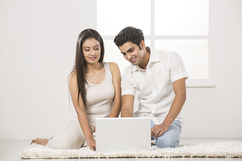 couple at home working on laptop