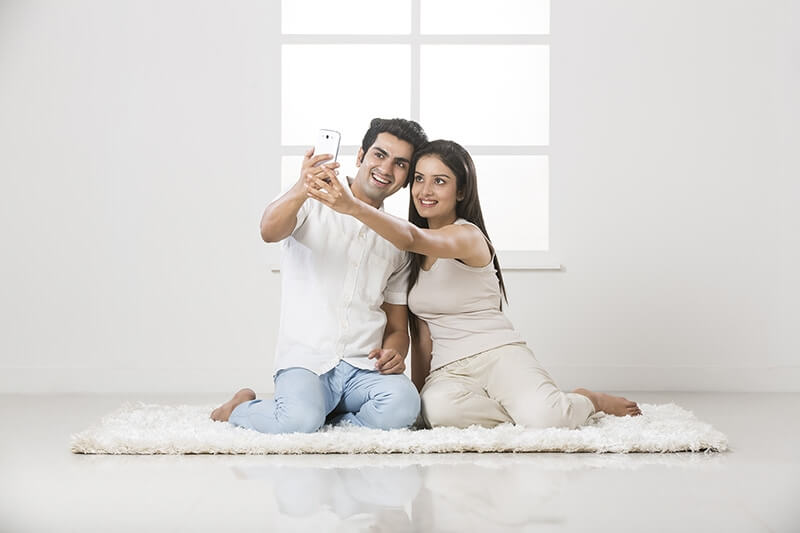 couple clicking picture with mobile phone at home