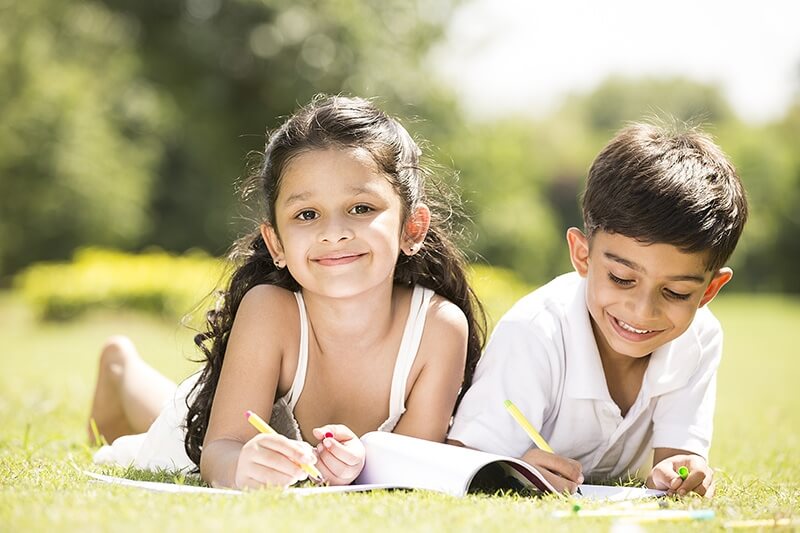 two kids studying in the park