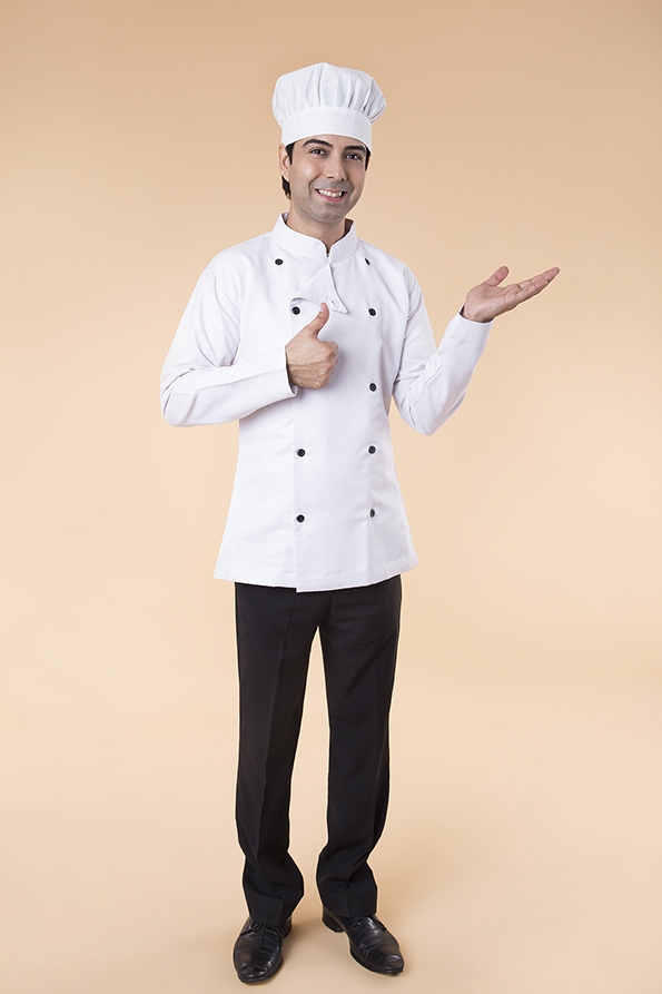 chef wearing chef cap pointing towards something